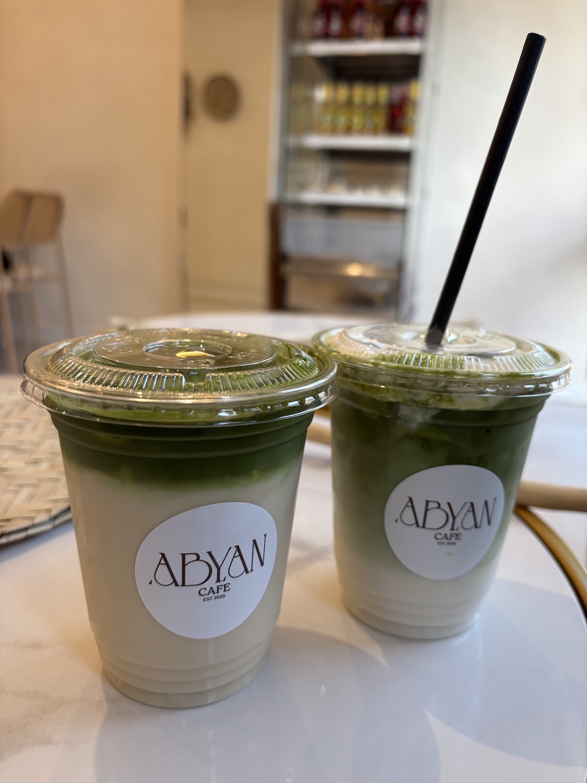 Two iced matcha drinks on the marble counter