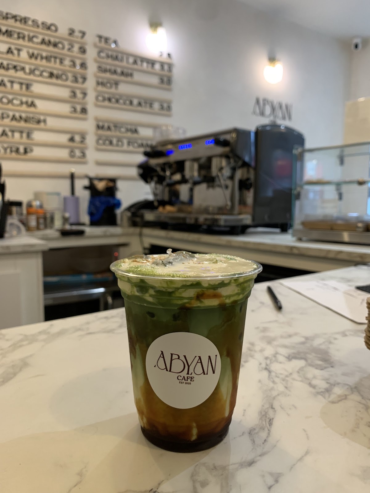 Iced matcha on marble in front of the espresso machine